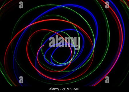 chaotic swirls of green red and blue light Stock Photo