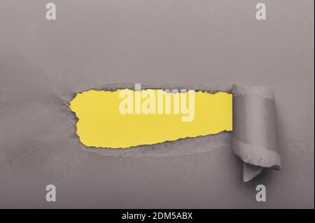 Gray torn paper with yellow paper on background Stock Photo