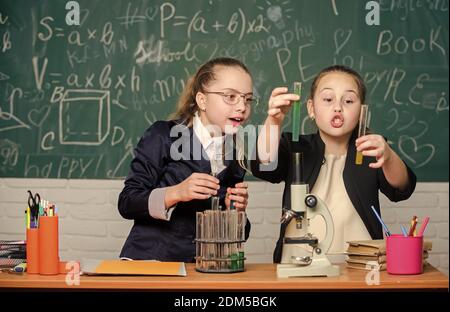 Hard choice. Chemistry research. Biology science. Happy little girls. Little girls in school lab. Science is future. science experiments in laboratory. Little girls scientist work with microscope. Stock Photo