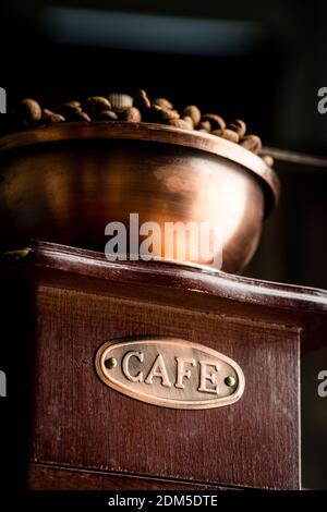 Vintage coffee grinder, in dark tones on the rustic wooden background. Old coffee making equipment. Selective focus. Shallow depth of field. Stock Photo
