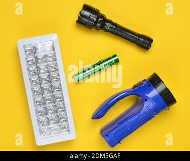 Lots of flashlights on a yellow background, top view Stock Photo