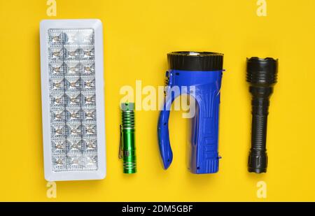 Lots of flashlights on a yellow background, top view Stock Photo