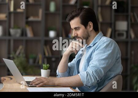 Pensive Caucasian man work on computer thinking Stock Photo
