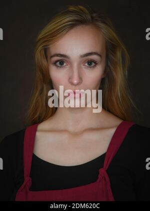Portrait of a natural complexion beautiful young women showing collar bones looking straight to camera shot in the studio against a brown canvas, Stock Photo