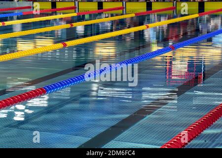 Quiet water in swimming pool - red, blue and yellow lane lines Stock Photo