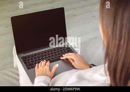 Close up of woman working at home on a laptop with black screen.Online education Stock Photo