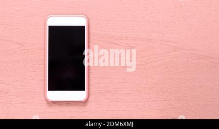 Top view of cell phone with black screen isolated on pink wooden textured background with ample copytext space. Smartphone Stock Photo