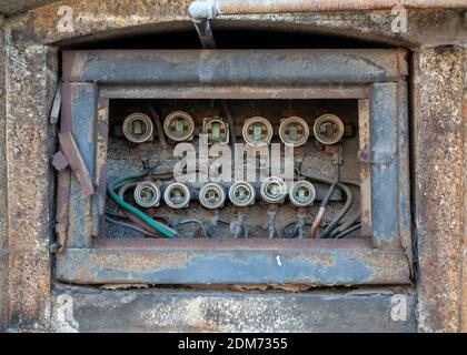 Disused old-fashioned electrical distribution board and old fuses in neglected abandoned building Stock Photo