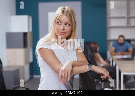 Beautiful female entrepreneur looking away thoughtfully, posing at the office Stock Photo