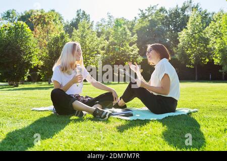 Female teacher psychologist social worker talking to teenage student on the lawn Stock Photo