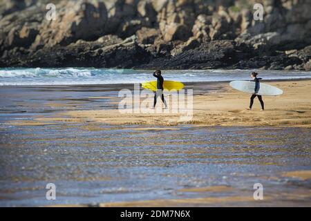 Surfers With Surfboards On Shore At Beach