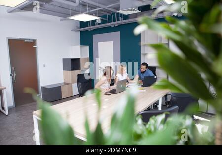 Young entrepreneurs having business meeting at open space office Stock Photo
