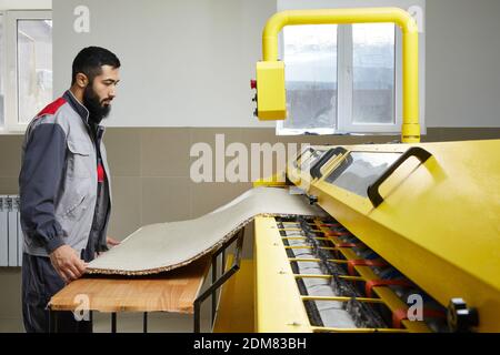Man operating carpet automatic washing machine in professional laundry service Stock Photo