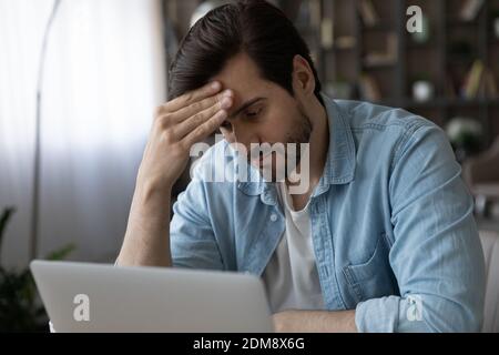 Pensive man look at laptop screen thinking Stock Photo