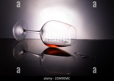 A cup of wine dripping liquid in a black background Stock Photo