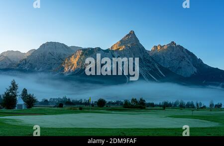 Golf Course On The Wetterstein Mountains In The Morning Mist Stock Photo