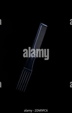 black plastic hair comb with reflection on black background Stock Photo