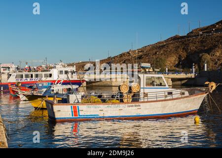 Traditional Fishing Tours boat docked in Mykonos new port marina at sunrise, Mykonos Island, Greece. Stock Photo