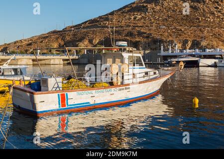 Traditional Fishing Tours boat moored in Mykonos new port marina at sunrise, Mykonos Island, Greece. Stock Photo