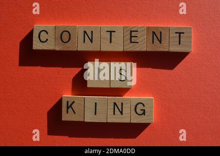 Content is King, words in wooden alphabet letters isolated on red background Stock Photo