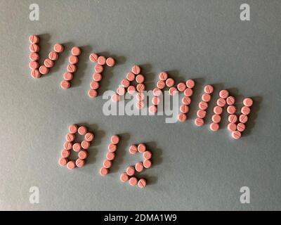 Vitamin B12, words in small pink tablets isolated on background Stock Photo