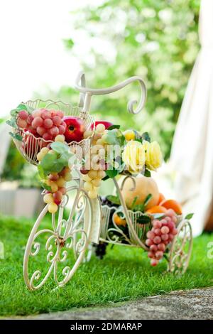 Decorative bicycle with fruit in basket on green summer background. Stock Photo