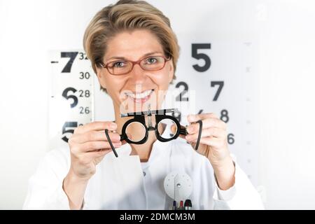 Young eye doctor W34 with testing frame on the eye chart, Germany, Europe
