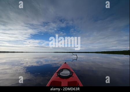 Red kayak on Coot Bay in Everglades National Park, Florida under winter cloudscape reflected in tranquil water, Stock Photo