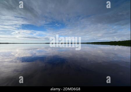 Winter cloudscape reflected in tranquil water of Coot Bay in Everglades National Park in late afternoon. Stock Photo