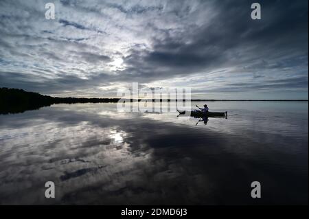 Everglades National Park, Florida - December 12, 2020 - Active senior kayaks at sunset under dramatic winter cloudscape in Coot Bay. Stock Photo