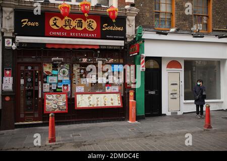 London, Britain. 16th Dec, 2020. A person stands outside a restaurant, which is offering takeaway service only, in Chinatown, London, Britain, on Dec. 16, 2020. London moved into Tier Three, the highest level in England's local coronavirus restriction tier system, from midnight on Wednesday. Credit: Tim Ireland/Xinhua/Alamy Live News Stock Photo