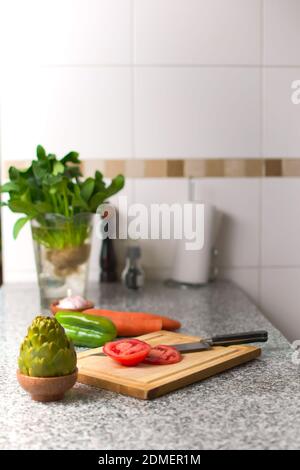 Bell pepper on a cutting board, and fresh ingredients over a kitchen countertop. Stock Photo