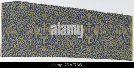 Fragment, Medium: silk, metallic thread (beaten gold on vellum wrapped around linen core) Technique: 4&1 satin patterned with plain weave (lampas), Horizontal rows of medallions edged with small incurving scallops, each containing an ornamental fountain with confronted phoenixes with spread wings and necks bent to drink on either side; small mask at top, bottom, and sides of each medallion. On a close-set ground of floral arabesques in rich gold on a deep electric blue ground. Yellow selvedge on each side; pattern reversible., Italy, 14th century, woven textiles, Fragment Stock Photo
