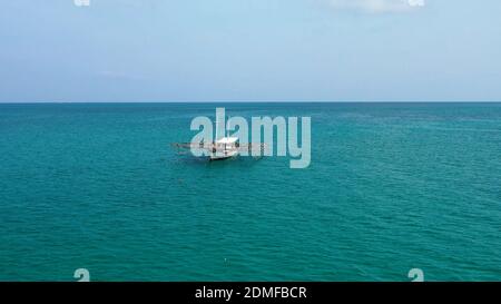 An aerial shot of a fishing boat on the turquoise sea Stock Photo