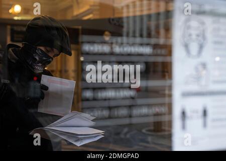 Ljubljana, Slovenia. 14th Dec, 2020. Sanel collects mails for customers at the post office in Ljubljana, capital of Slovenia, on Dec. 14, 2020. TO GO WITH 'Feature: A day in the life of Slovenian courier during pandemic' Credit: Zeljko Stevanic/Xinhua/Alamy Live News Stock Photo