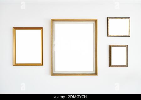 Vintage blank golden frames hanging on a white wall Stock Photo