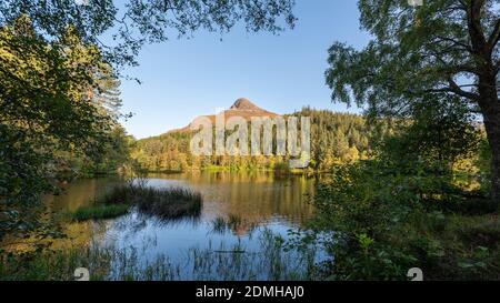 Pap of Glencoe is a familiar landmark around the lower end of the glen and Loch Leven. Pictured here with the reflection of the mountain in the water Stock Photo