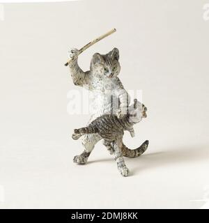 Cat and kitten, Cast and painted brass, Gray, black, and white tabby cat standing on hind legs holds an upraised stick above a mewing kitten lying across its knee, as if in the act of spanking., probably Austria, late 19th–early 20th century, miniatures, Decorative Arts, Figure, Figure Stock Photo