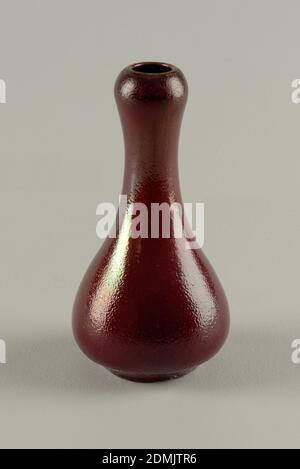 Vase, Dedham Pottery, Earthenware, oxblood, Gray-white stoneware body, thrown. Bulbous body with tapering neck; with slightly bulging area below rim; flat foot. Covered with a deep red or scarlet glaze with slight golden luster effect. Black striations through glaze. Very dark red at rim bulge. Dimpled surface allover. Interior glazed. Bottom not glazed. Glaze very thick at base., Chelsea, Massachusetts, USA, 1884–88, ceramics, Decorative Arts, Vase Stock Photo