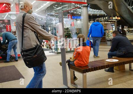 LUBIN, POLAND - DECEMBER 05, 2020. People with face masks due to pandemic Covid-19 disinfected hands at the entrance to shopping mall Cuprum Arena. Stock Photo