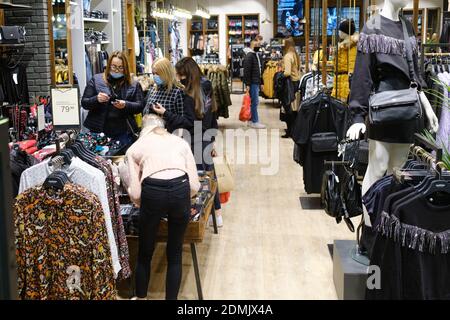 LUBIN, POLAND - DECEMBER 05, 2020. Women with face masks due to pandemic Covid-19 during the shopping in cloth shop. Stock Photo
