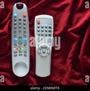 TV remote controls on a red silk background Stock Photo