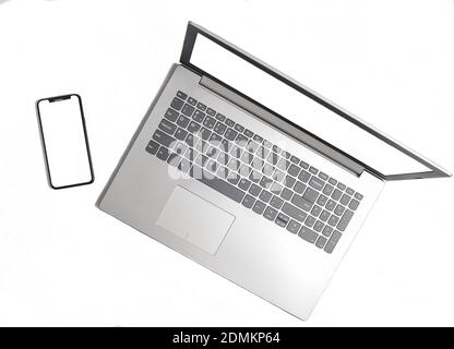Laptop and frameless phone on a white background. Modern technological gadgets, white screens for copy space Stock Photo