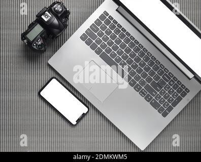 Laptop, frameless phone with white screen, camera on a gray texture surface, top view, copy space Stock Photo