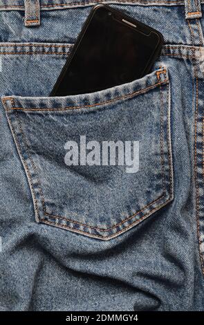 Smartphone in the back pocket of crumpled jeans Stock Photo