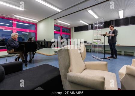 Singing lessons according to a specially developed hygiene concept with distance and a plexiglass pane Stock Photo