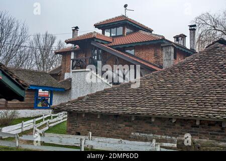 A view of a beautiful house in an even more beautiful environment. An old path with a wooden fence leads to the house. Stock Photo