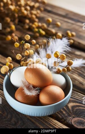 White and brown easter eggs in a bowl on dark wooden table. Stock Photo