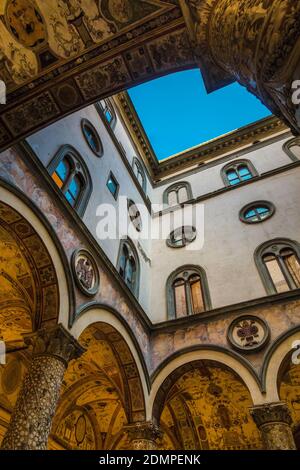 Lovely low-angle view of the charming inner courtyard in the Palazzo Vecchio, Florence. The columns are covered in gilt and stucco while the cross... Stock Photo