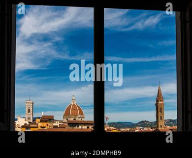 Beautiful panoramic rooftop view of Giotto's Campanile, the Florence Cathedral's dome with cupola and the bell tower of the Badia Fiorentina church,... Stock Photo
